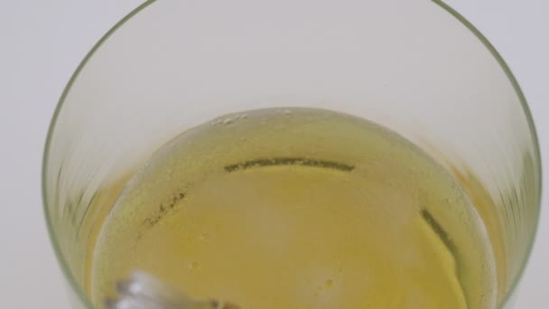 Slow motion. Beer is poured into a glass on a white background. Top view of a glass with bubbles. — Stock Video