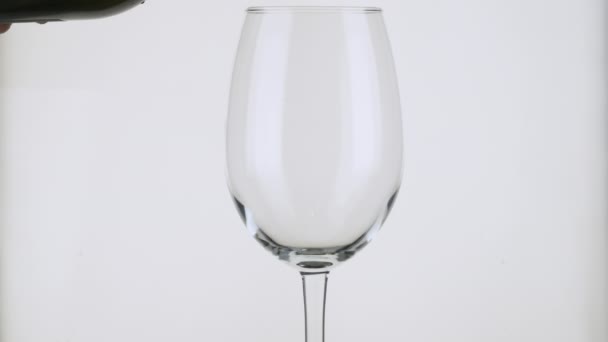 Langzame beweging. Witte wijn wordt in een wijnglas gegoten. — Stockvideo
