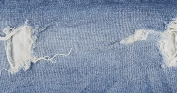 Rotatie, blauwe gescheurde jeans met gaten. Jeans textuur. — Stockvideo