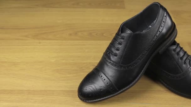 Ein Paar schwarze klassische Schnürschuhe, die auf dem Boden stehen. Schieber-Schuss. — Stockvideo