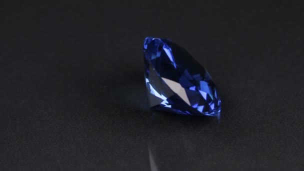 Rotation of a large blue rhinestone on a black background. Fashion background. — Stock Video