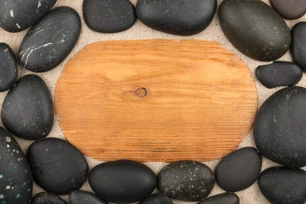 在沙滩上的空木架和黑色的石头 复制空间 顶部视图 — 图库照片