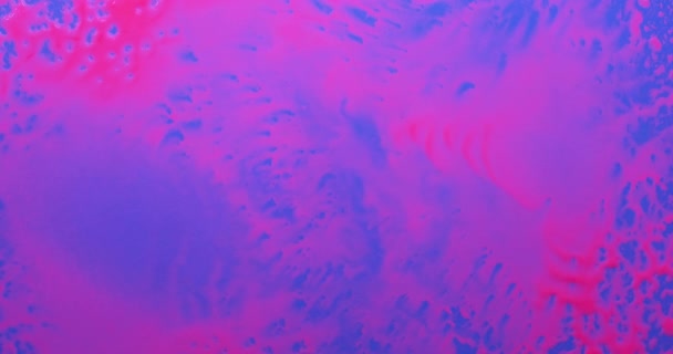 Des rafales chaotiques de vent soufflent la peinture fluorescente rose sur le fond bleu. — Video