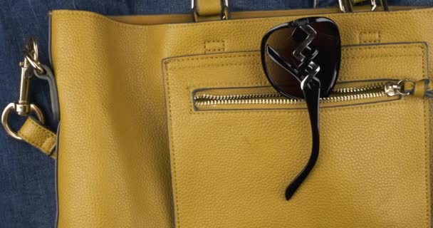 Sarı bir kadın çantasının cebinde güneş gözlüğü. Panorama. — Stok video