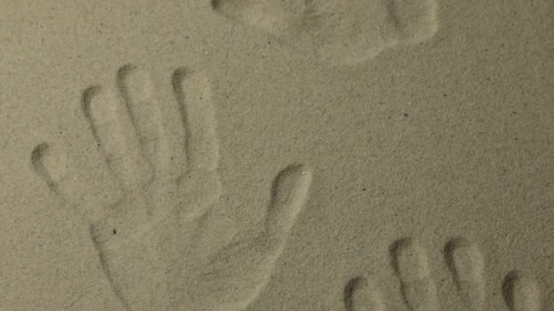 Håndflateavtrykk i sanden. Panorama. – stockvideo