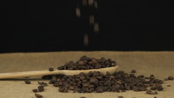 Boabele de cafea cad într-o lingură de lemn și se toarnă grămadă. Slow motion . — Videoclip de stoc