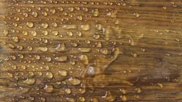 En cámara lenta. El viento sopla de corrientes de agua de una vieja superficie de madera. — Vídeos de Stock