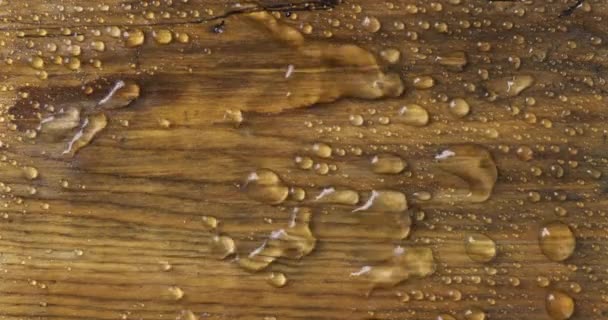 Viento soplando sobre gotas de lluvia en una tabla de madera. — Vídeos de Stock