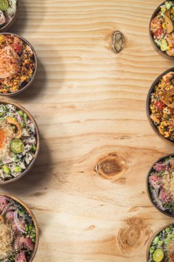 Tahta masadaki kaselerde Hawaii yemeği. Kopyalama alanı olan üst görünüm