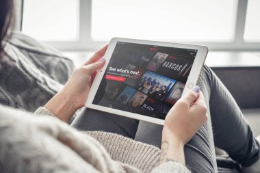 Kiev, Ukrain - February 10, 2018: Woman using Netflix app on a brand new Apple iPad Pro Silver, 7th generation of the iPad, developed by Apple inc. and was announced on March 21, 2016 clipart