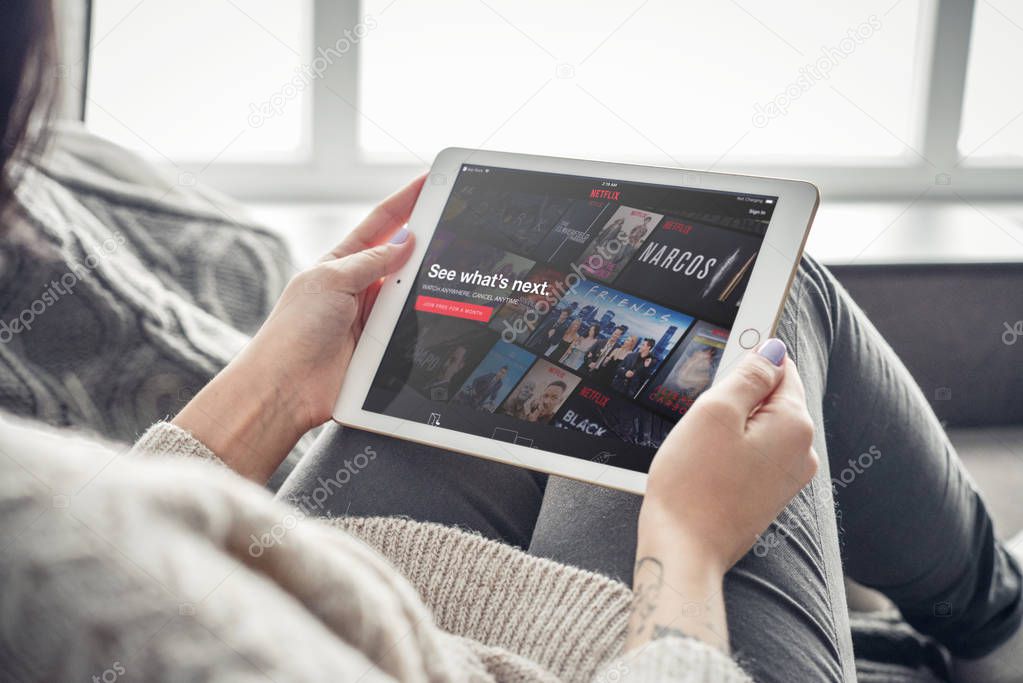 Kiev, Ukrain - February 10, 2018: Woman using Netflix app on a brand new Apple iPad Pro Silver, 7th generation of the iPad, developed by Apple inc. and was announced on March 21, 2016