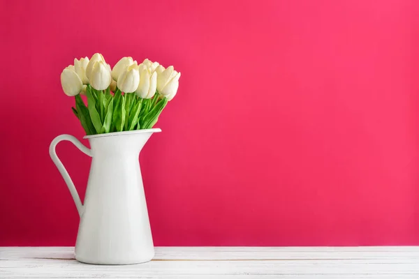 粉红色背景白色搪瓷壶白色郁金香花束 — 图库照片