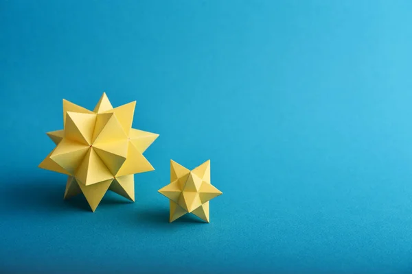 Dois Poliedros Papel Amarelo Feitos Mão Sobre Fundo Azul — Fotografia de Stock