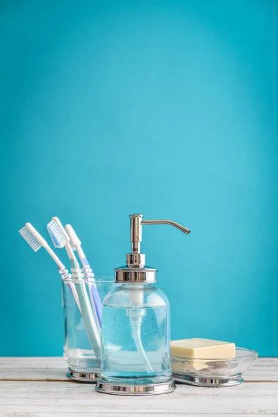Bathroom set with toothbrushes and soap on blue background