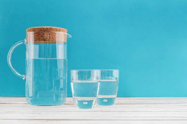 Kruik Twee Glas Met Helder Water Blauwe Achtergrond — Stockfoto