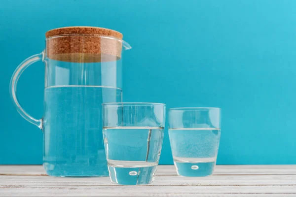 Jarra Dos Vasos Con Agua Clara Sobre Fondo Azul — Foto de Stock