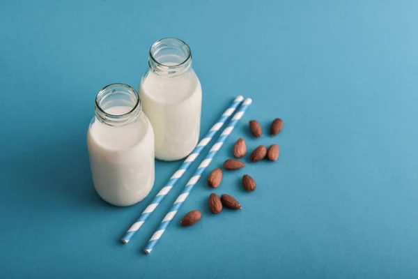 Миндальное Молоко Бутылках Миндалем Соломинками Синем Фоне — стоковое фото