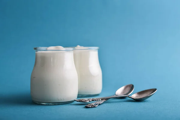 Grekisk Yoghurt Glas Burkar Med Skedar Blå Bakgrund Närbild — Stockfoto