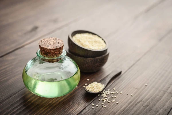 Sesamöl Glasflasche Und Samen Auf Holzgrund — Stockfoto