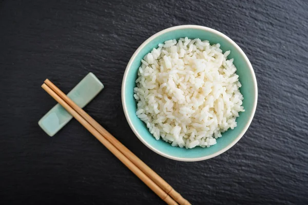 Arroz Cozido Tigela Pauzinhos Bambu Fundo Ardósia Preta Vista Superior — Fotografia de Stock