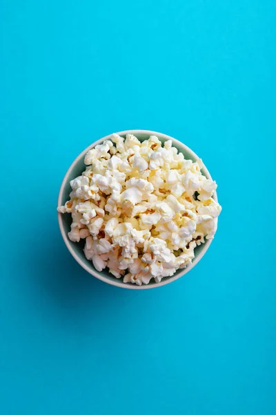 Popcorn Een Kom Blauwe Achtergrond Bovenaanzicht — Stockfoto