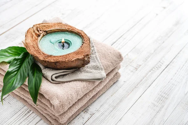 Kerze Kokosnussschale Auf Einem Stapel Handtücher Auf Hellem Hintergrund Spa — Stockfoto
