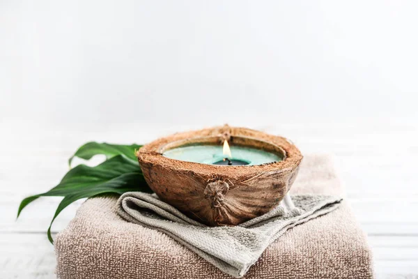 Kerze Kokosnussschale Auf Einem Stapel Handtücher Auf Hellem Hintergrund Spa — Stockfoto