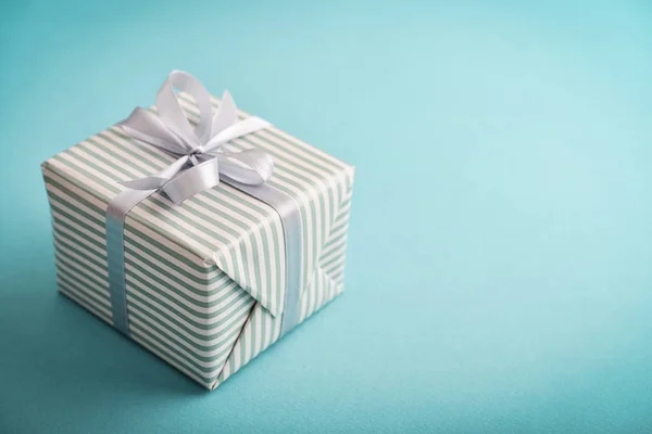 One Striped Gift Box Grey Ribbon Blue Background Closeu — Stock Photo, Image