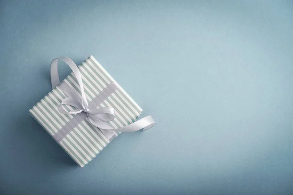 One Striped Gift Box Grey Ribbon Blue Background Closeup — Stock Photo, Image