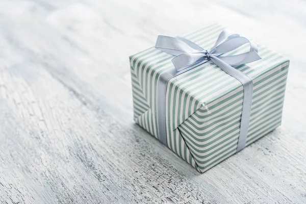 One Striped Gift Box Grey Ribbon White Wooden Background Closeup — Stock Photo, Image