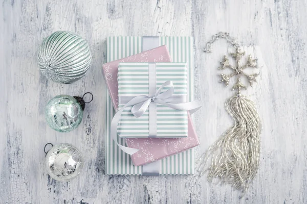 Stapel Geschenkdozen Met Kerstdecoratie Vorm Van Sneeuwvlok Witte Houten Achtergrond — Stockfoto