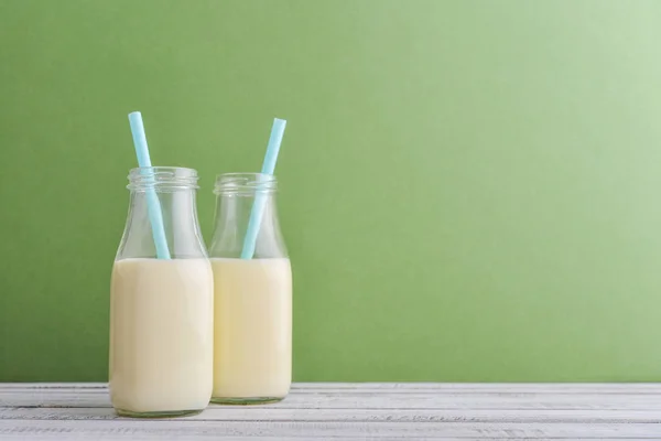 Dos Botellas Con Leche Pajitas Para Beber Sobre Fondo Verde —  Fotos de Stock