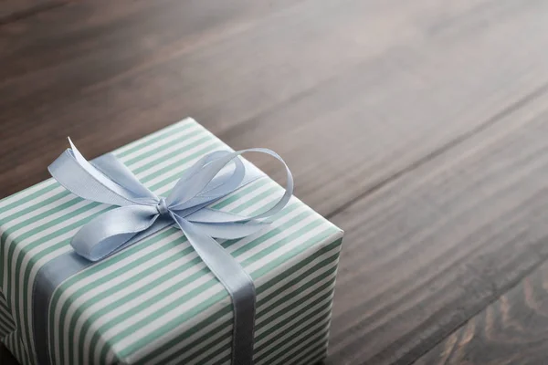 Striped Gift Box Blue Ribbon Wooden Background Closeup — Stock Photo, Image