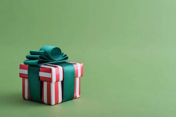Rode Gestreepte Geschenkdoos Met Groene Lint Groene Achtergrond Closeup — Stockfoto