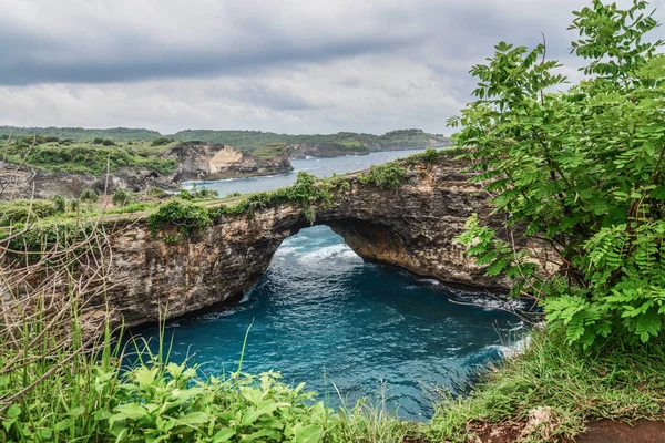 Rock coastline. Stone arch over the sea. Broken beach, Nusa Penida ,Indonesia.