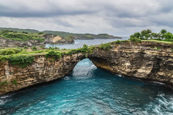 Rock coastline. Stone arch over the sea. Broken beach, Nusa Penida ,Indonesia.