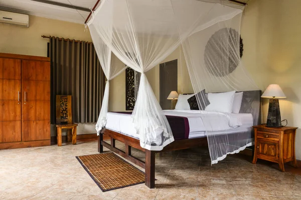 Уютная кровать с балдахином в традиционном балийском доме — стоковое фото