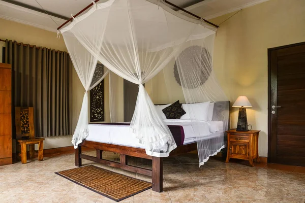 Уютная кровать с балдахином в традиционном балийском доме — стоковое фото