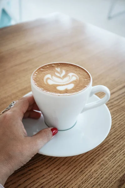 Tangan wanita memegang cangkir cappuccino — Stok Foto