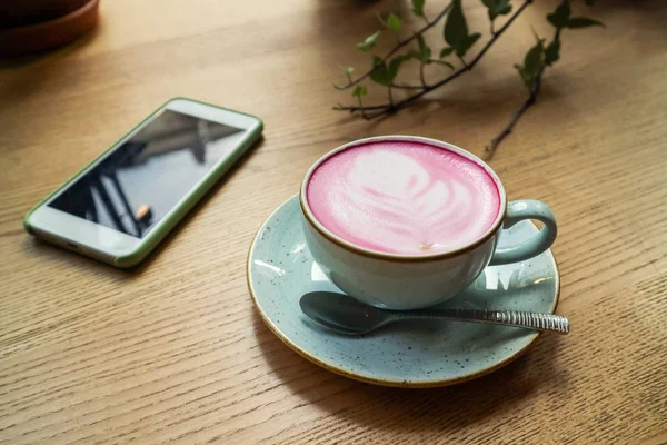 Šálek růžového cappuccino v modrém poháru — Stock fotografie