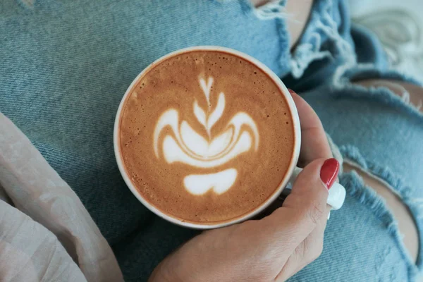 La mano femenina sostiene una taza de capuchino —  Fotos de Stock