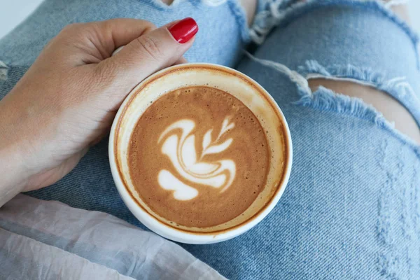 La mano femenina sostiene una taza de capuchino —  Fotos de Stock