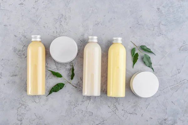 Botellas con productos cosméticos de spa sobre fondo gris —  Fotos de Stock