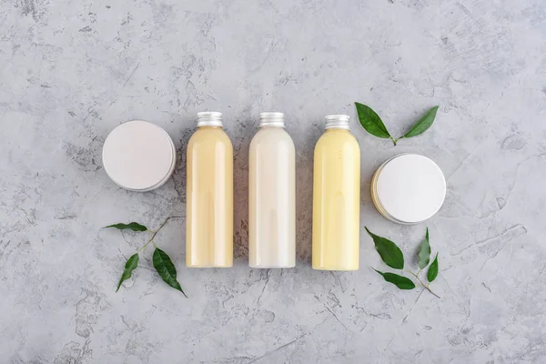 Botellas con productos cosméticos de spa sobre fondo gris —  Fotos de Stock