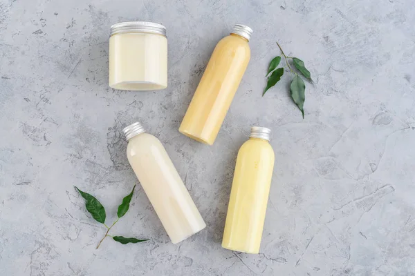 Botellas con productos cosméticos de spa sobre fondo gris —  Fotos de Stock