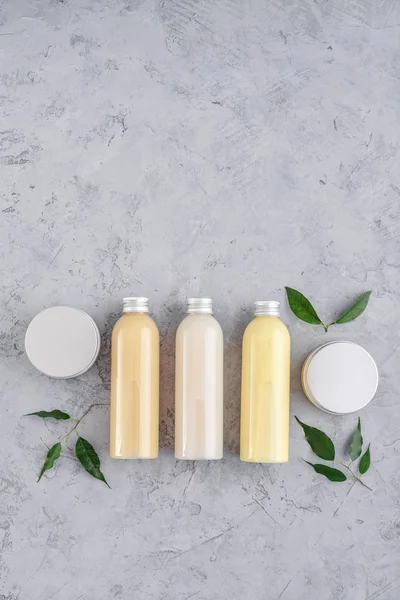 Botellas con productos cosméticos de spa sobre fondo gris —  Fotos de Stock