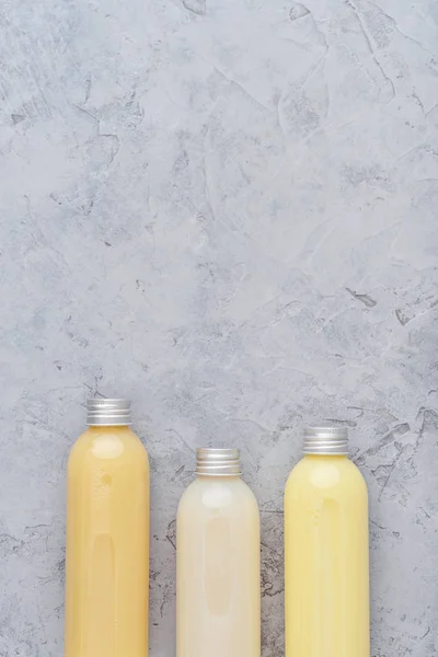 Botellas con productos cosméticos de spa sobre fondo gris —  Fotos de Stock