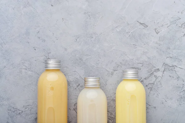 Botellas con productos cosméticos de spa sobre fondo gris —  Fotos de Stock