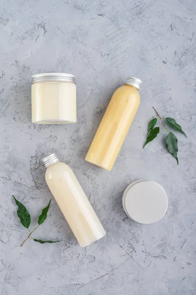 Botellas con productos cosméticos de spa sobre fondo gris —  Fotos de Stock