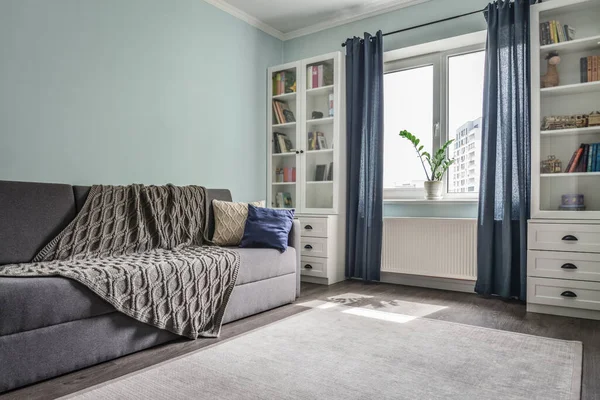 轻盈舒适的青少年房间 配有白色书柜 灰色沙发和蓝色墙壁 — 图库照片